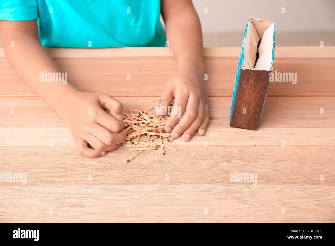 Little African-American boy with matches at table. Child in danger Stock Photo
