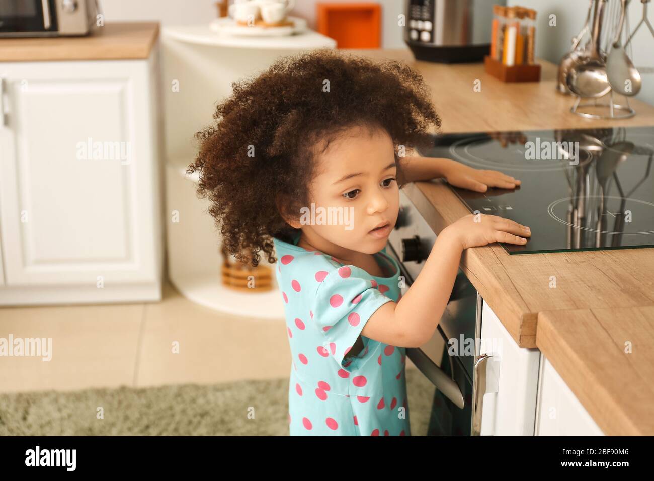 Little African American Girl Playing With Stove In Kitchen Child In Danger Stock Photo Alamy