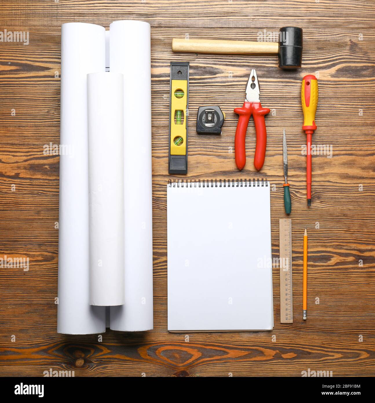 Blueprints with builder's tools and notebook on wooden background Stock Photo