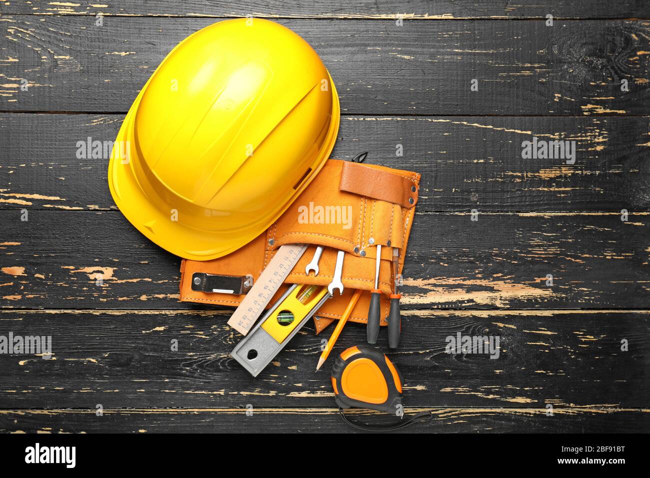 Builder's tools and hardhat on wooden background Stock Photo