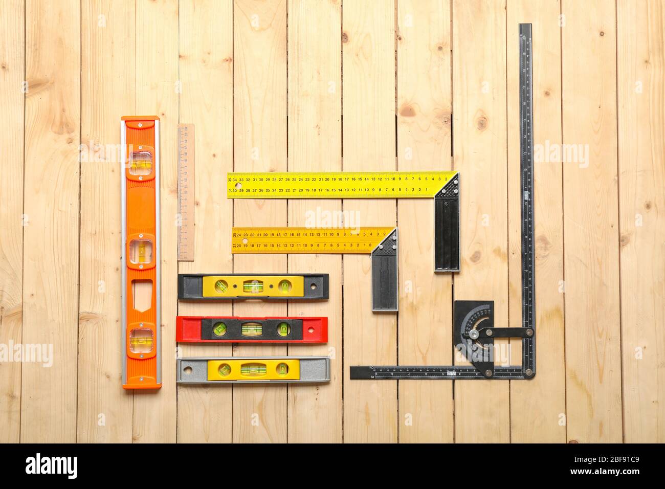 Builder's rulers on wooden background Stock Photo - Alamy