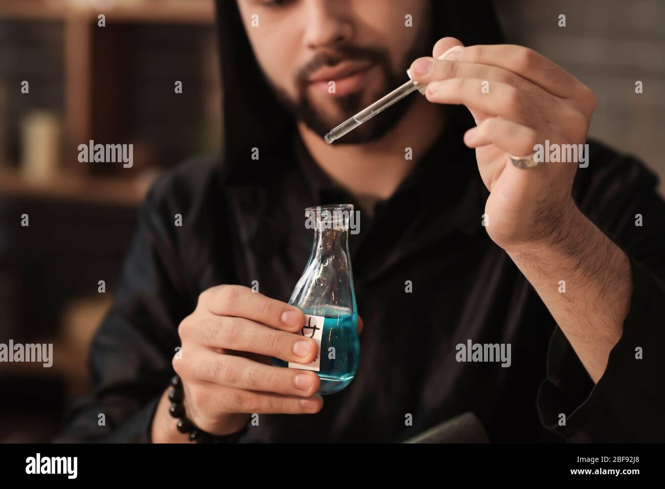 Male alchemist making elixir in laboratory Stock Photo