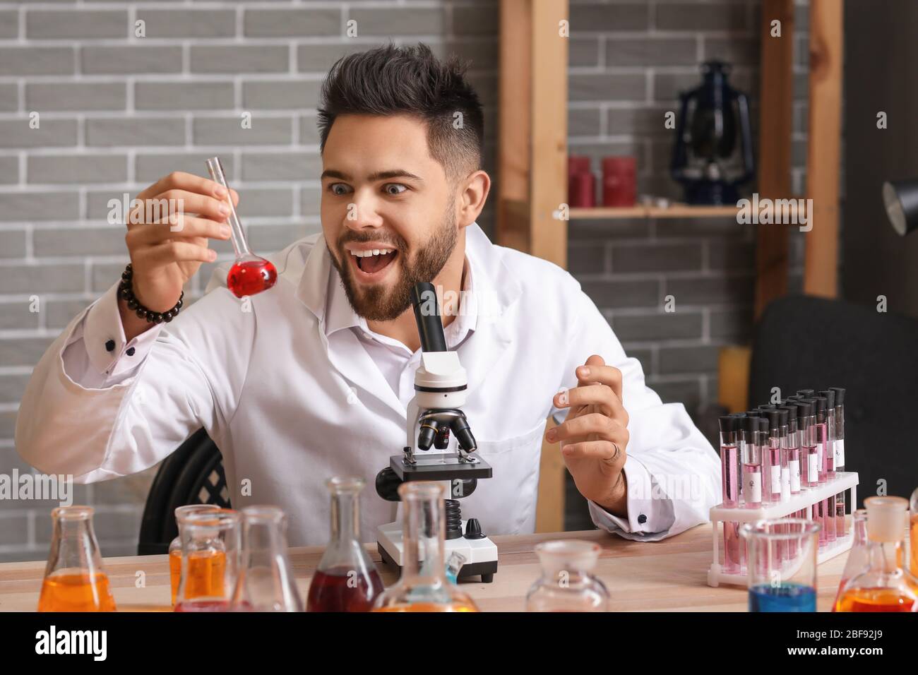 Crazy male alchemist working in laboratory Stock Photo