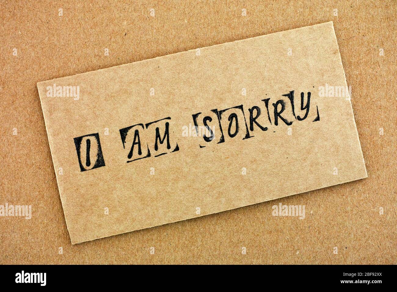 Cardboard with words I am Sorry made by black alphabet stamps. Stock Photo