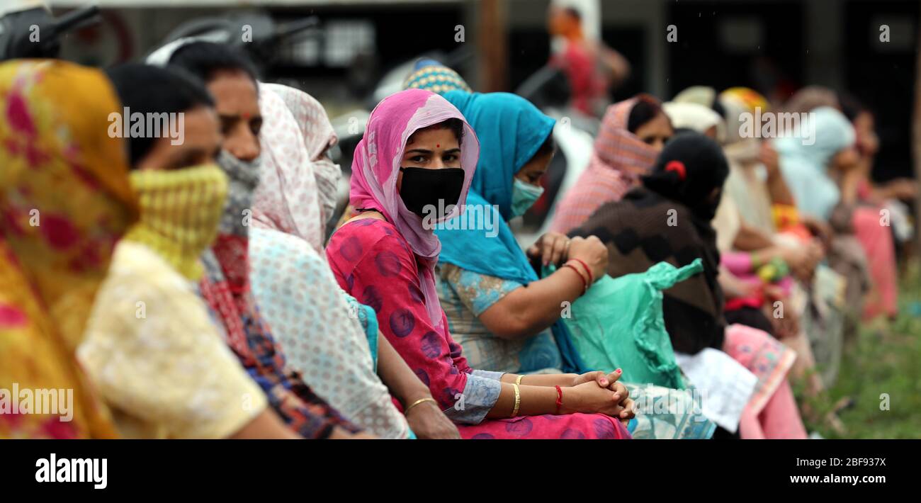 Jammu, Indian-controlled Kashmir. 17th Apr, 2020. People sit in queue as they wait for food distributed by police during the lockdown to contain the spread of novel coronavirus, in Jammu, the winter capital of Indian-controlled Kashmir, April 17, 2020. Credit: Str/Xinhua/Alamy Live News Stock Photo