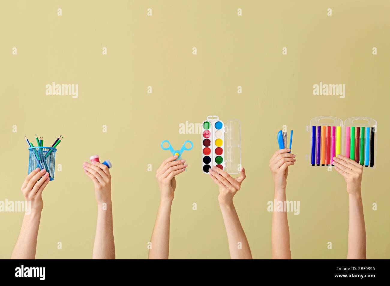 Many hands with school supplies on color background Stock Photo - Alamy