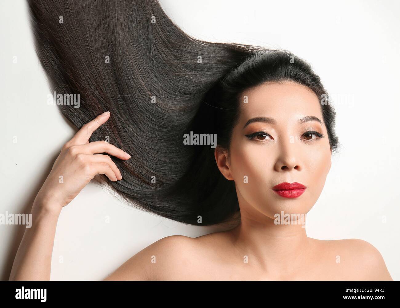 Young Asian woman with beautiful hair on white background Stock Photo ...