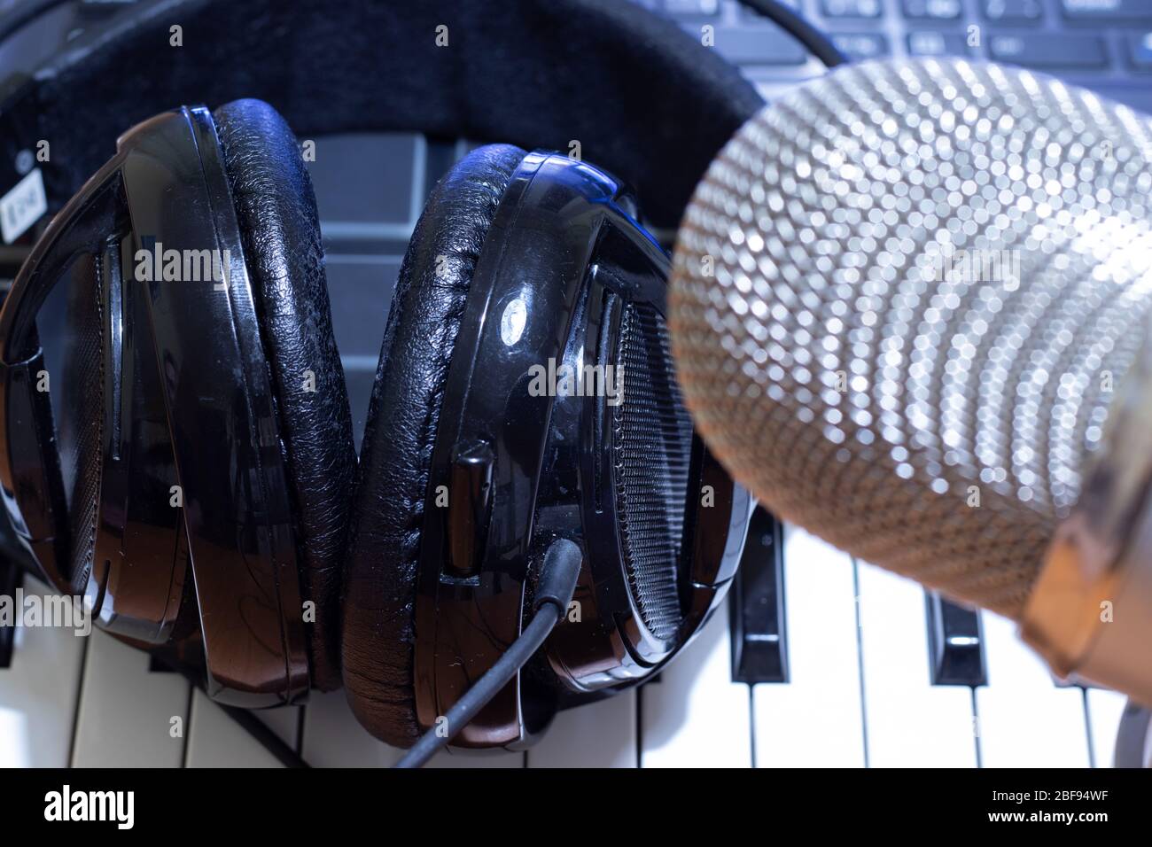 Headphones on synth piano keyboard and head of condenser microphone. Making  music concept Stock Photo - Alamy