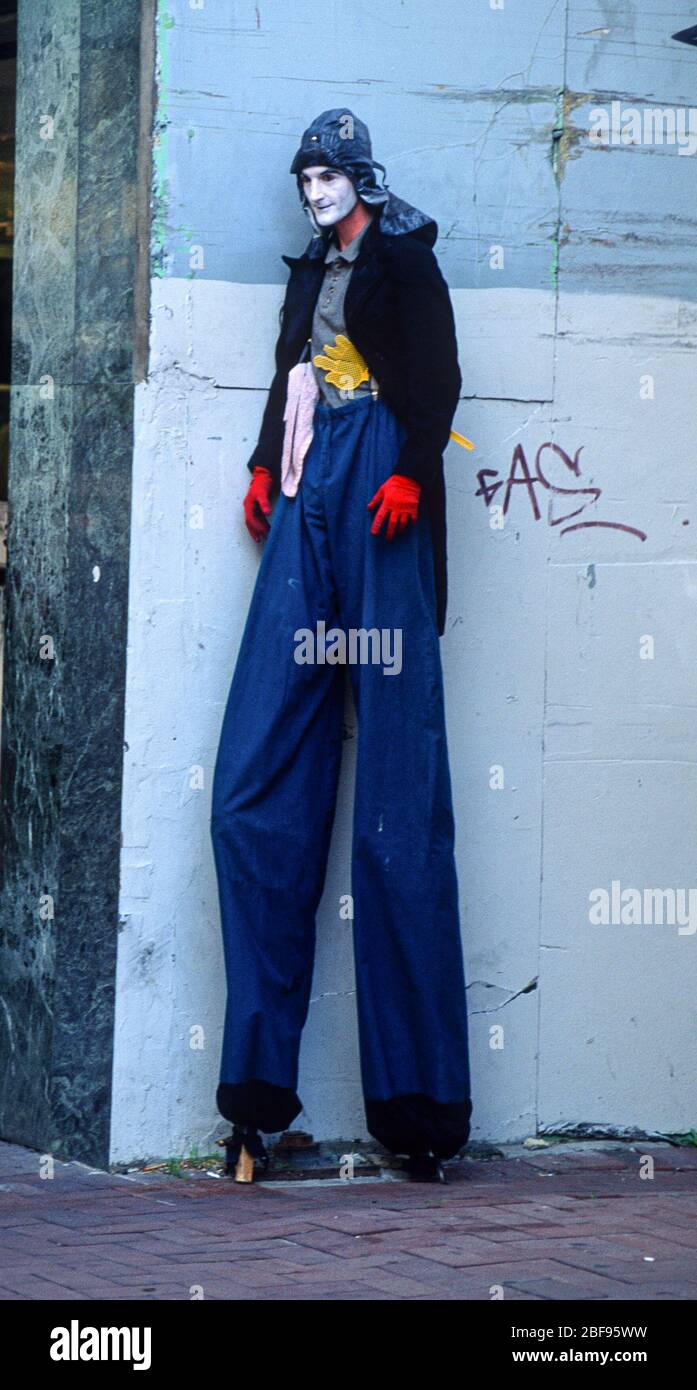 Walking tall, a man on stilts wearing blue trousers, Perth, Australia, July 1995 Stock Photo