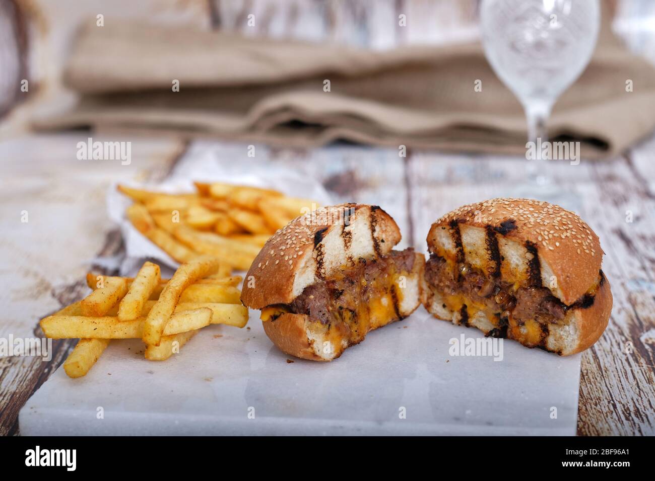 Fast Food, Hamburger. Special veal prepared hamburger, french fries and double cheddar cheese. Close-up fresh delicious tasty homemade burger. Stock Photo
