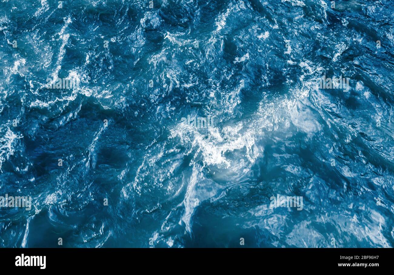 Deep blue stormy ocean water with splashes and foam, top view ...