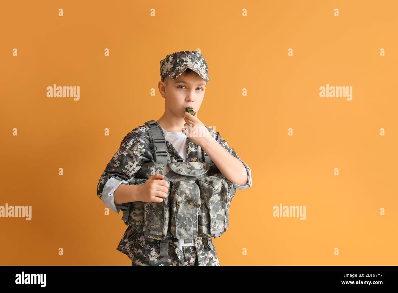 Cute little soldier with whistle on color background Stock Photo