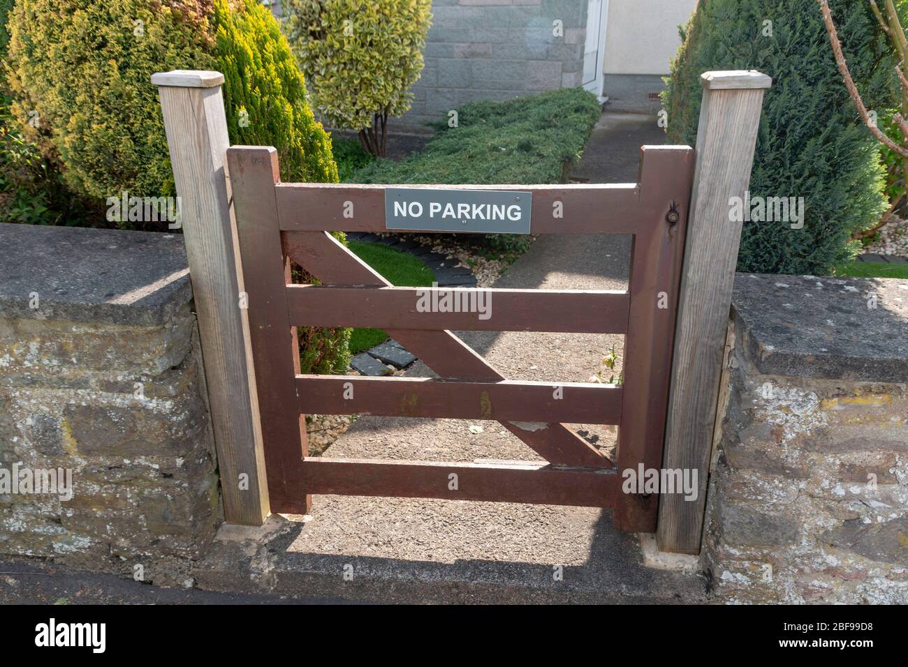 a close up view of a front gate that has a no parkign sign on the front Stock Photo