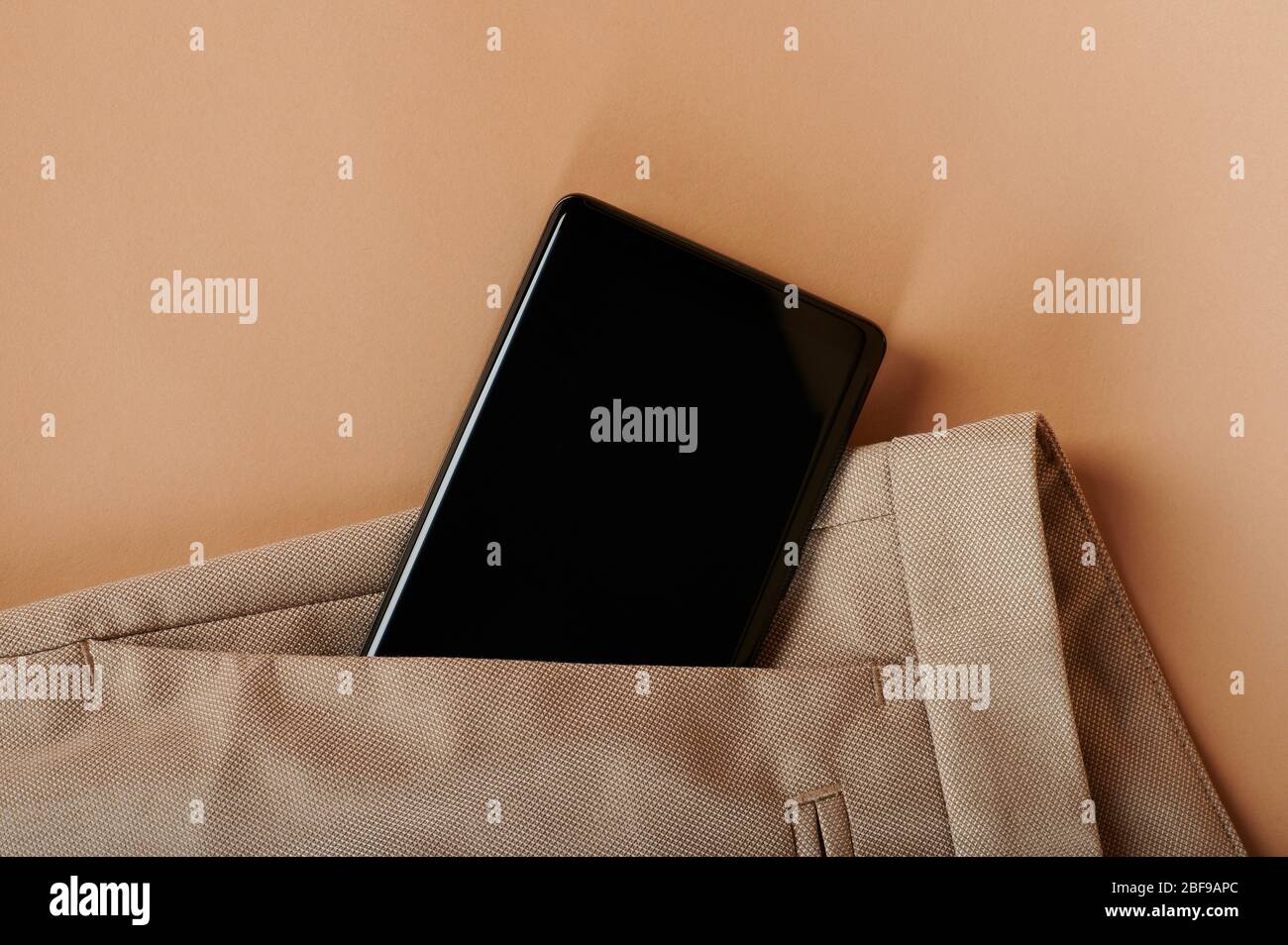 Black screen of smartphone in beige color pants pocket Stock Photo