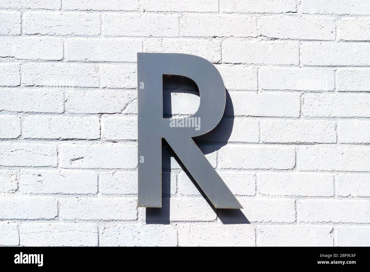 The letter R as a capital letter on a white brick wall Stock Photo - Alamy