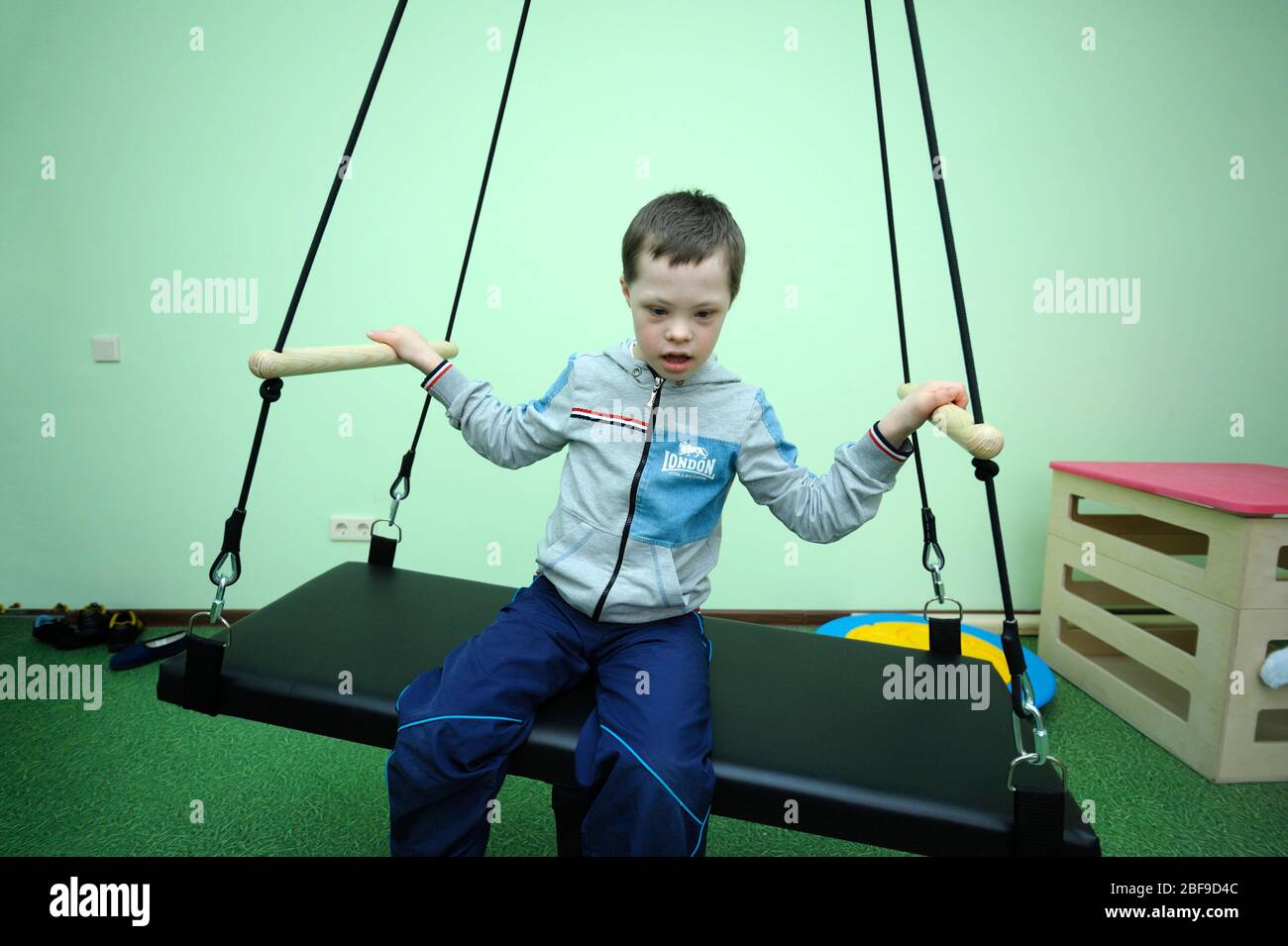 Improving motor control female therapist helping Down syndrome boy to