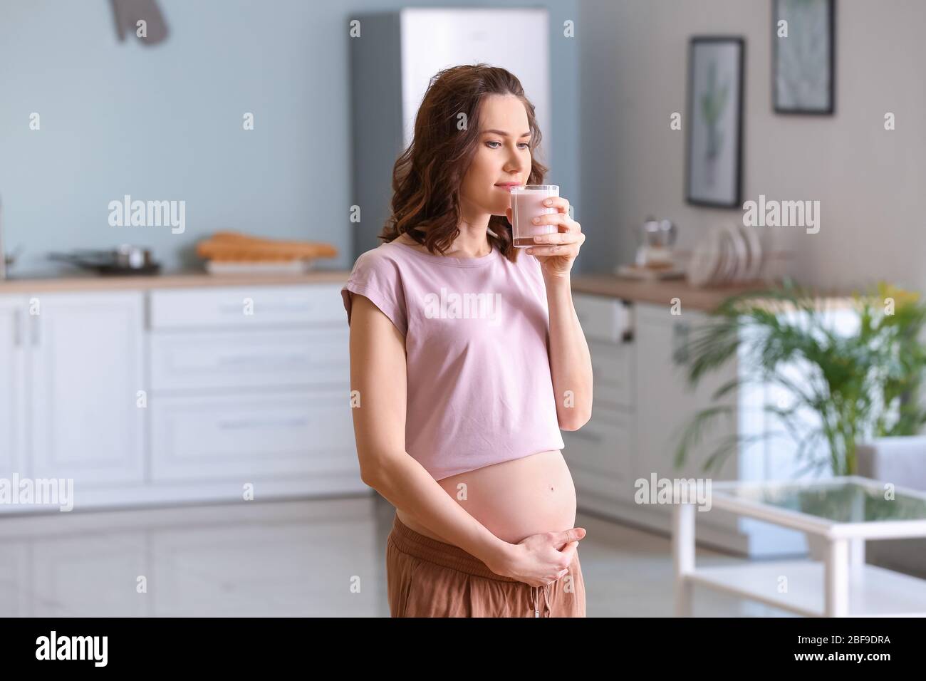 Beautiful pregnant woman with healthy yogurt at home Stock Photo Alamy