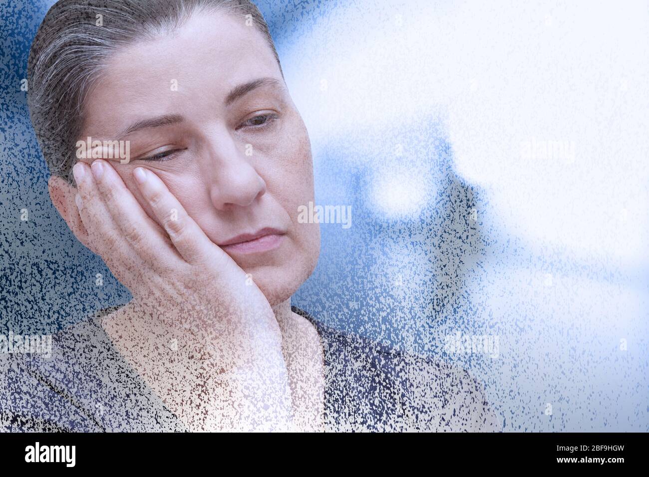 Fibromyalgia symptom fatigue: exhausted woman falling asleep in the office, particle dispersion effect. Stock Photo