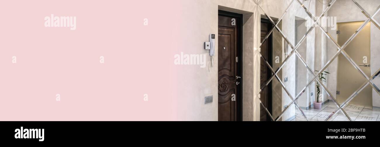 Bright entrance hall in a modern style with a large mirror on the wall. Comfortable living space in a city house. Stock Photo