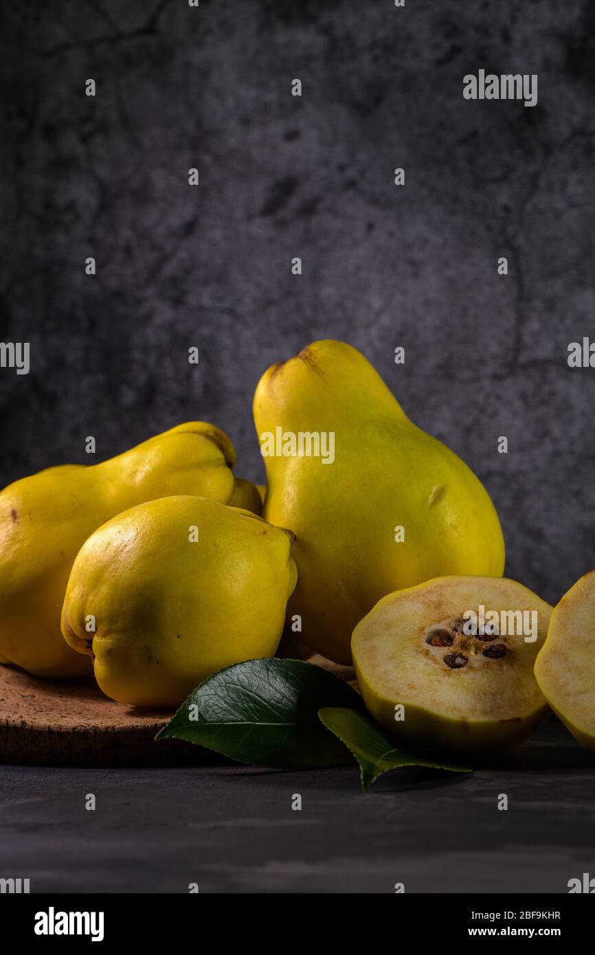 Ripe yellow quinces or queen apple fruits and sliced quince halves with ...