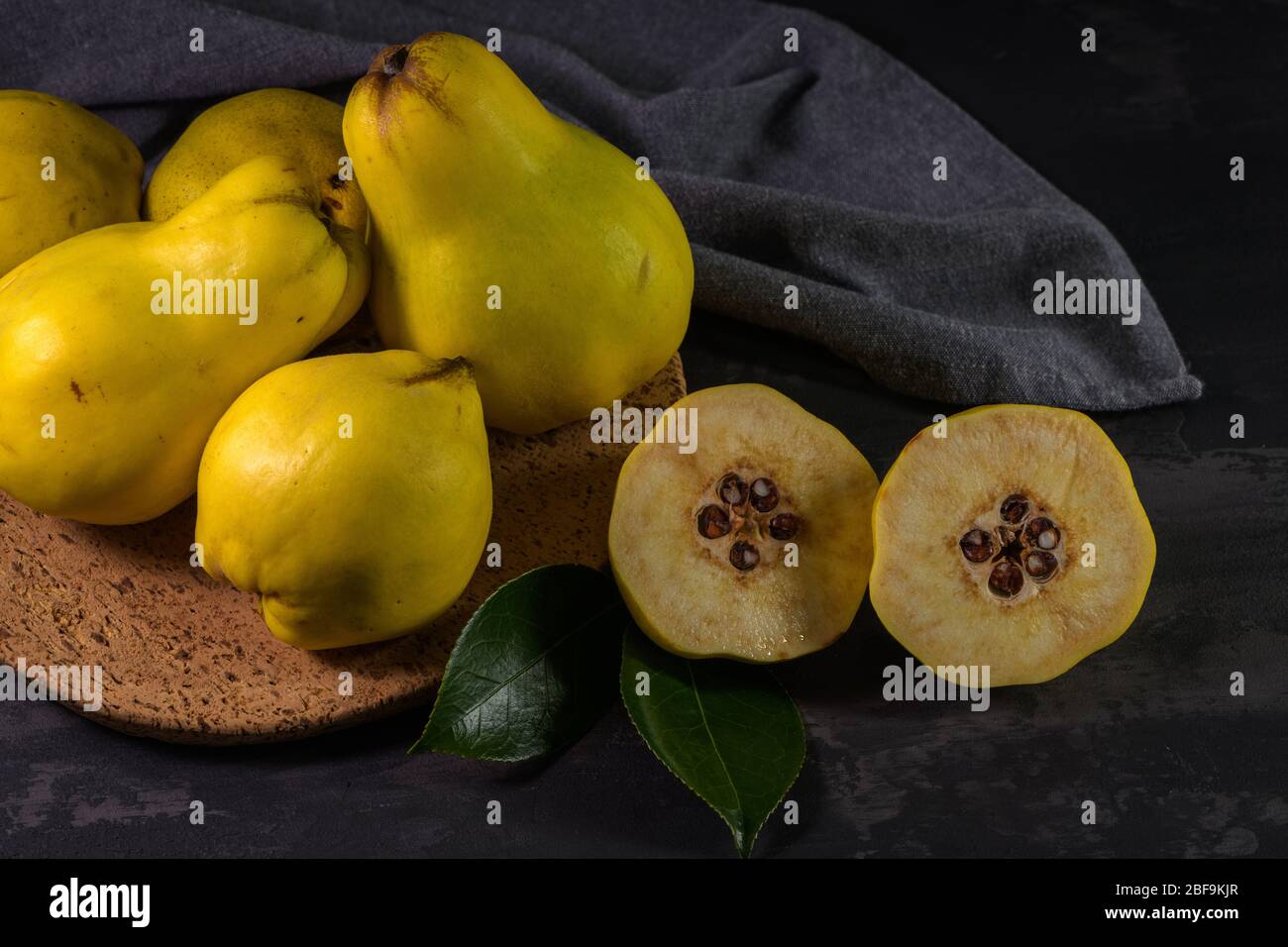 Ripe yellow quinces or queen apple fruits and sliced quince halves with
