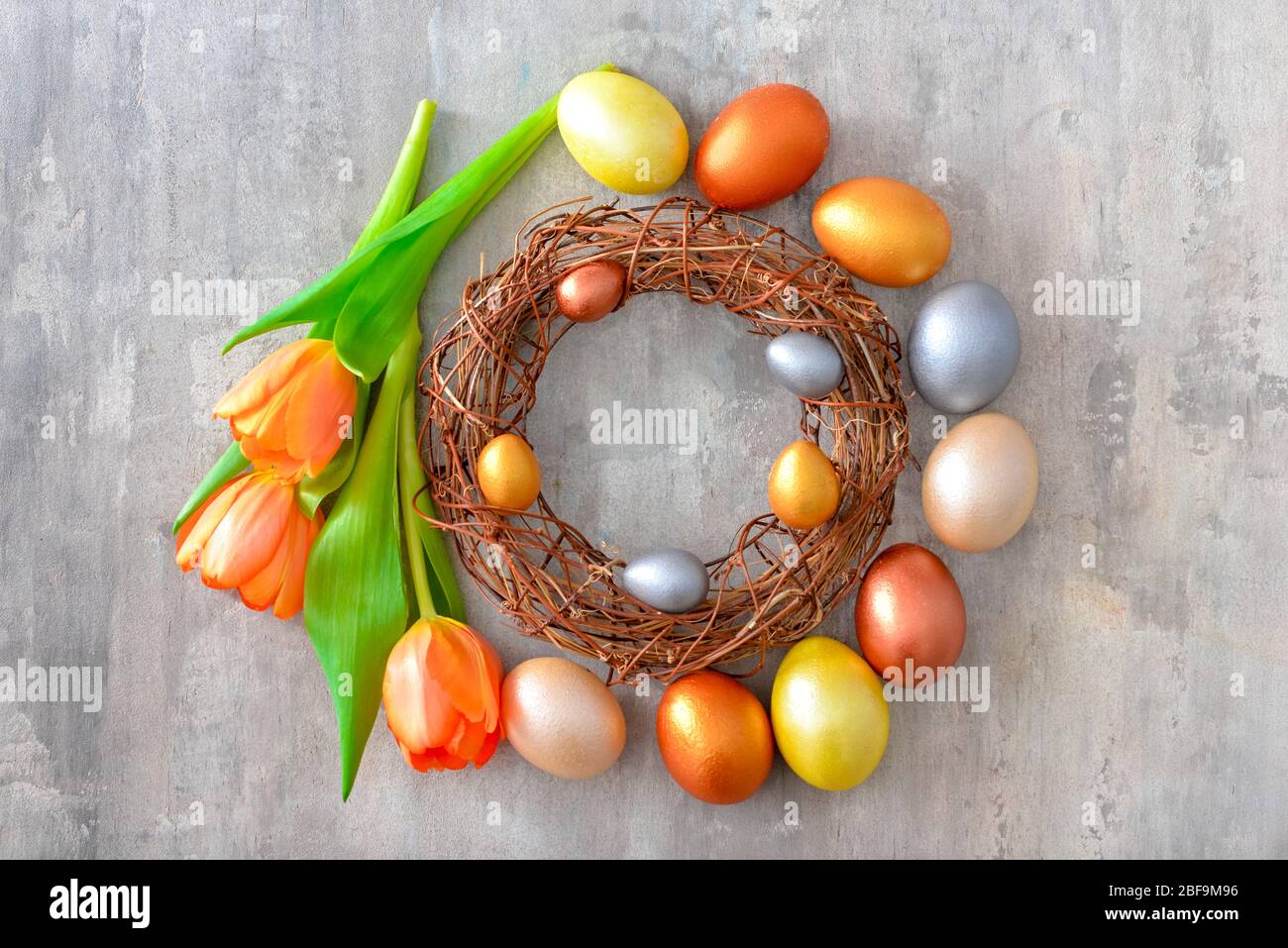 Nest with beautiful Easter eggs and flowers on grey background Stock ...