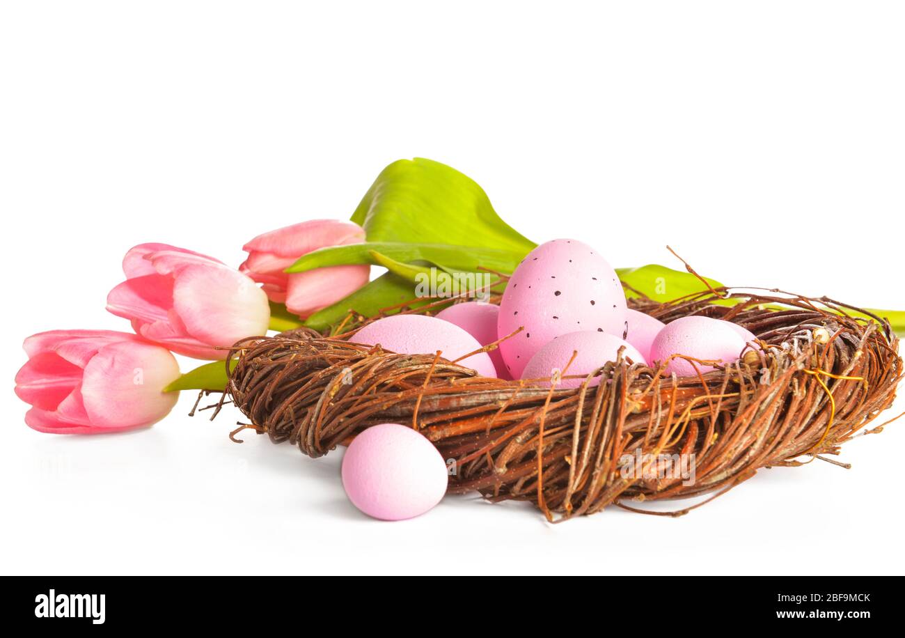Nest with beautiful Easter eggs and flowers on white background Stock ...