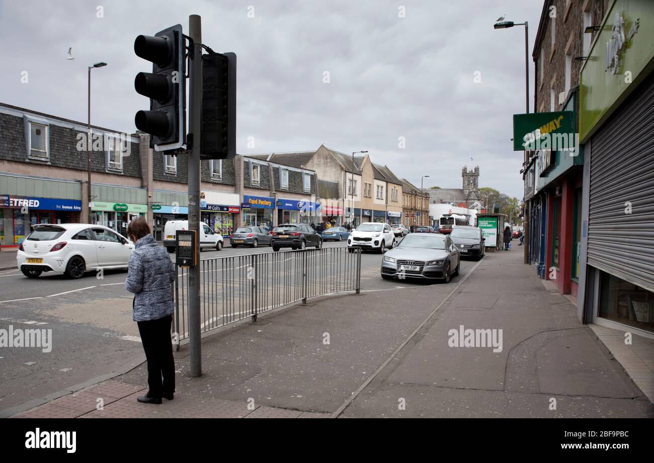 Musselburgh, High Street, East Lothian, Scotland, UK. The normally bustling main street in normal times shows very quiet pavements due to the Coronavirus Lockdown but several cars passing through. Stock Photo