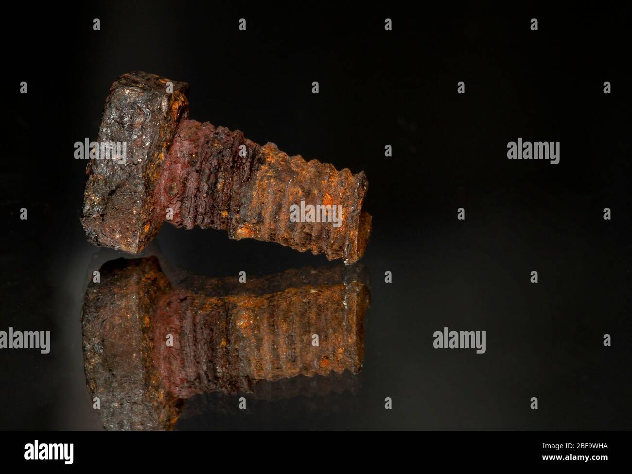 Rusted screw closeup view on black background Stock Photo