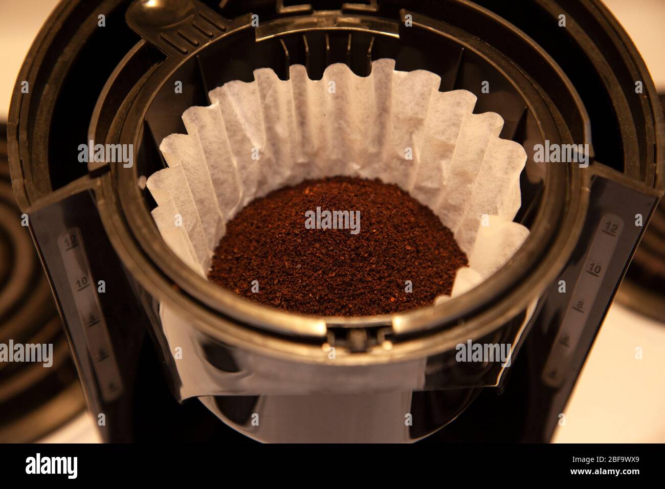 a paper filter is full of fresh coffee grinds ready for brewing Stock Photo