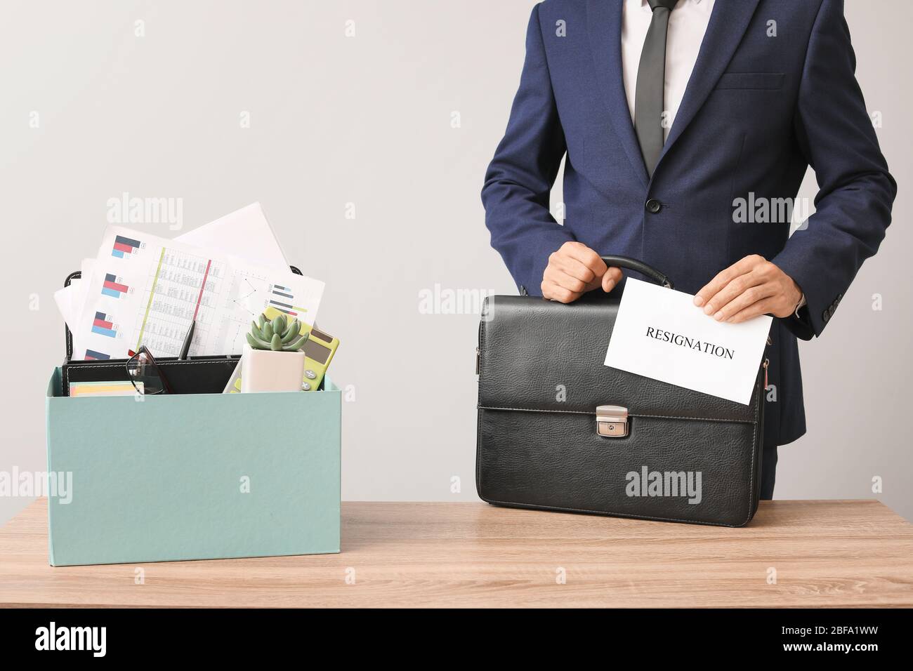 Fired worker with personal things at table Stock Photo Alamy