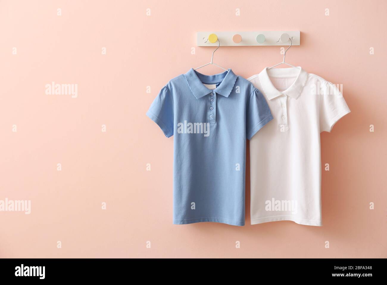 Stylish school uniform hanging on color wall Stock Photo - Alamy