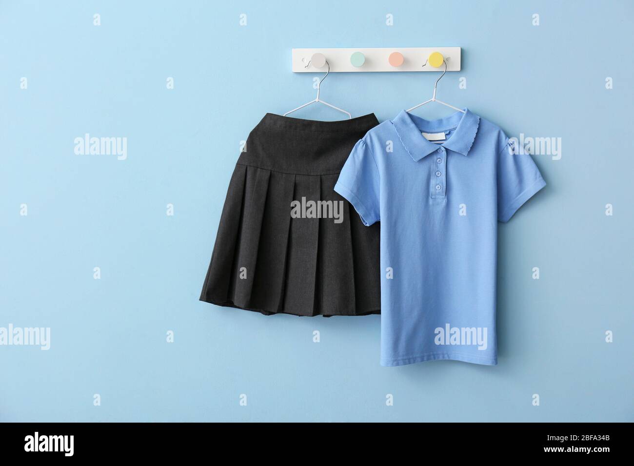 Stylish school uniform hanging on color wall Stock Photo Alamy
