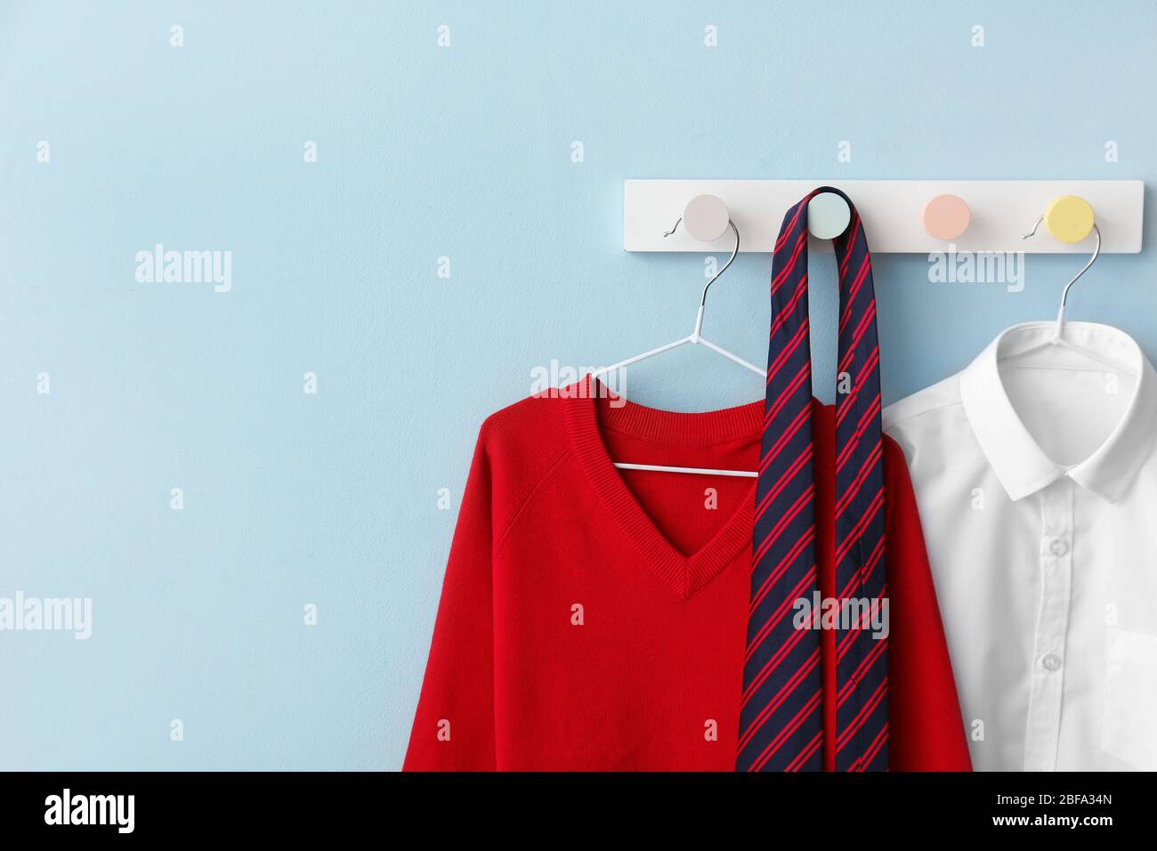 Stylish school uniform hanging on color wall Stock Photo Alamy