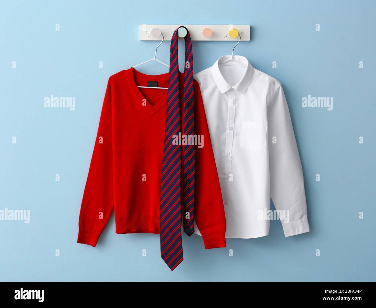 Stylish school uniform hanging on color wall Stock Photo Alamy
