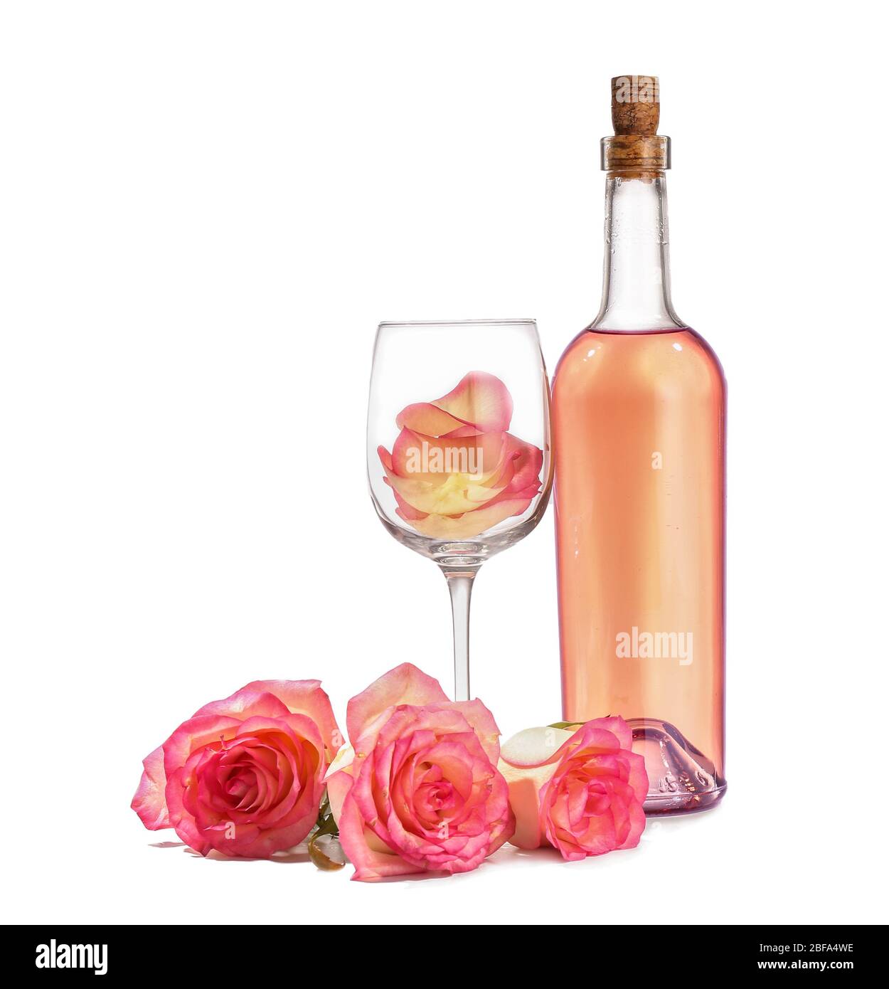Glass and bottle of wine with rose flowers on white background Stock