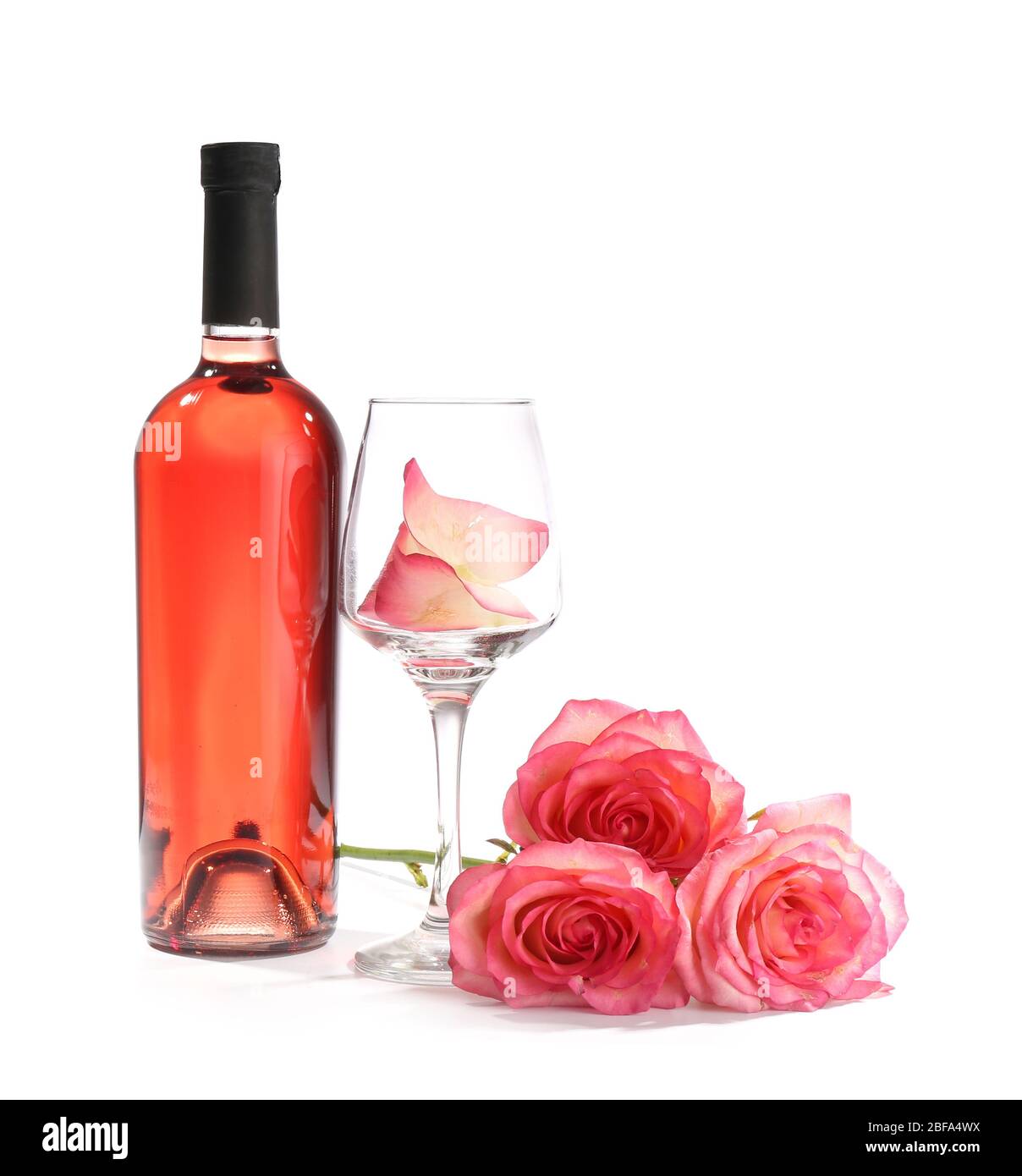 Glass and bottle of wine with rose flowers on white background Stock