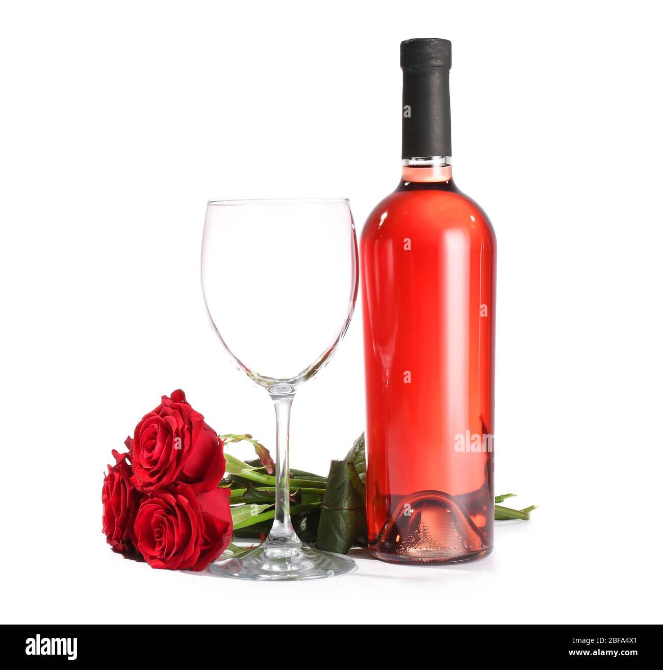 Glass and bottle of wine with rose flowers on white background Stock