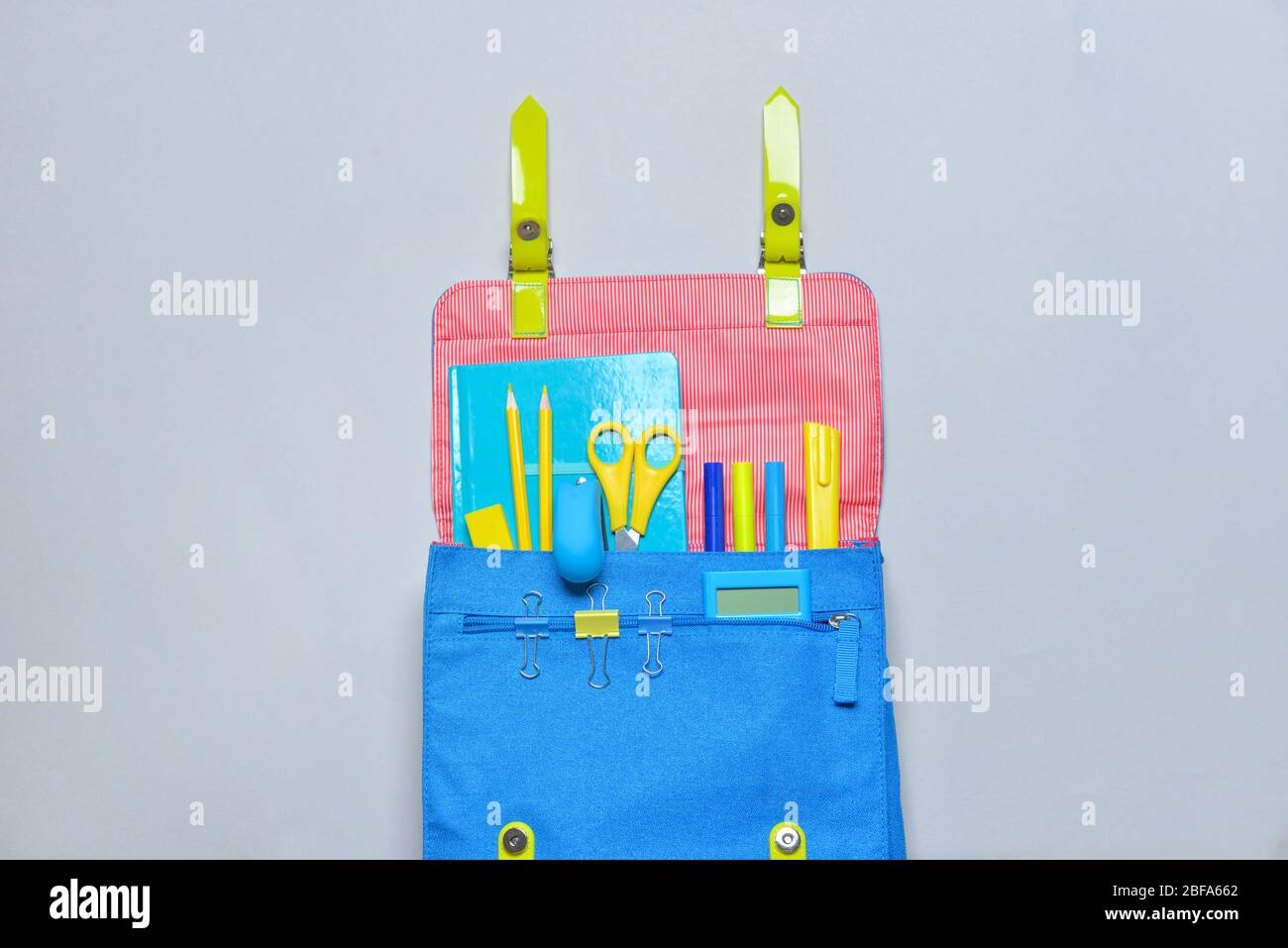 School backpack and stationery on grey background Stock Photo