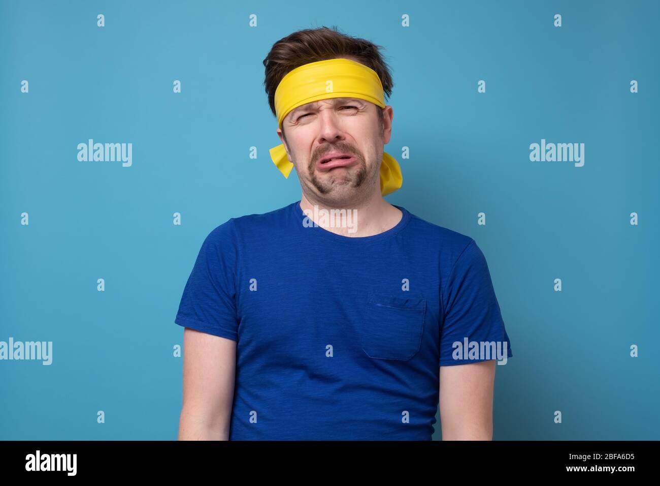 Young caucasian sport man with yellow rubber band whining and crying disconsolately Stock Photo