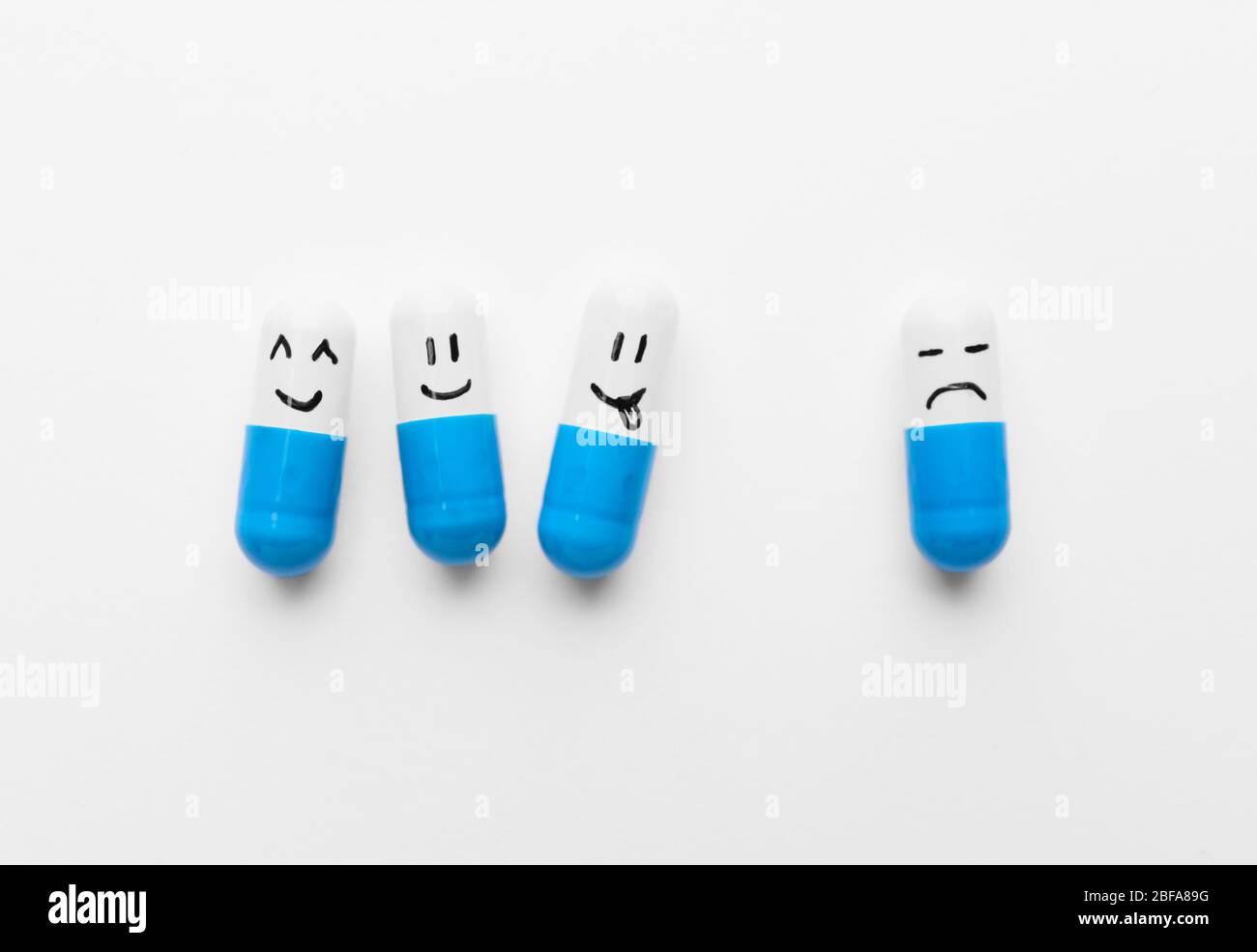 Pills with different drawn faces on white background Stock Photo - Alamy