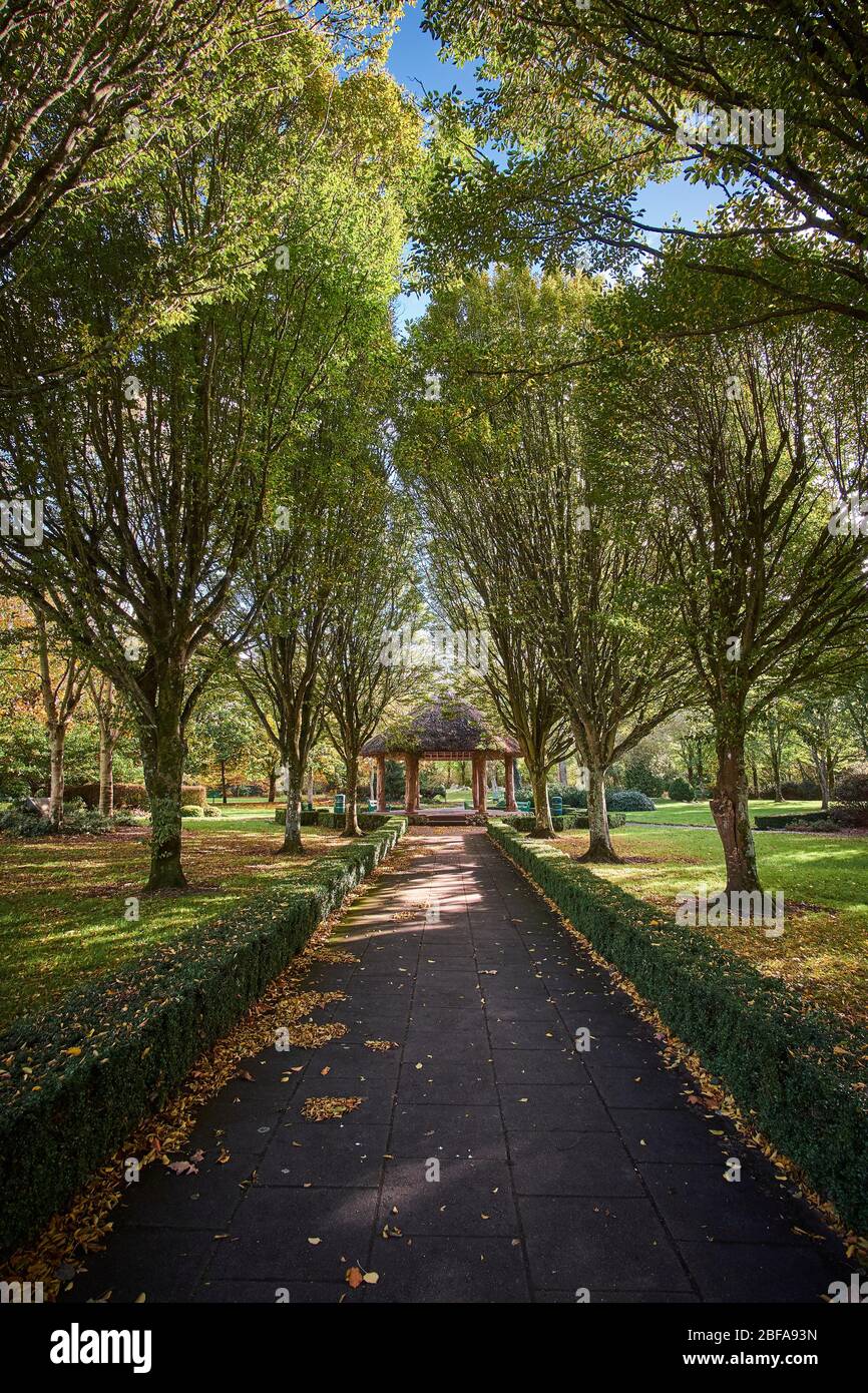 Peaceful view of the City park in Adare, County Limerick, Republic of Ireland on a autumn fall day in October looking down walkway toward gazebo Stock Photo