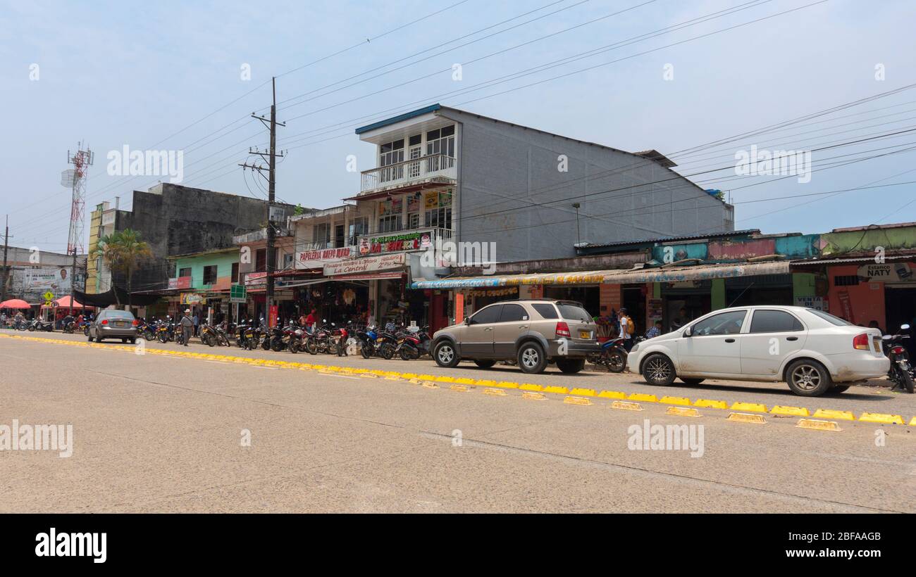 La Dorada, Putumayo / Colombia - March 8 2020: People walking on the main road full of motorcycles and cars circulating on a sunny day Stock Photo