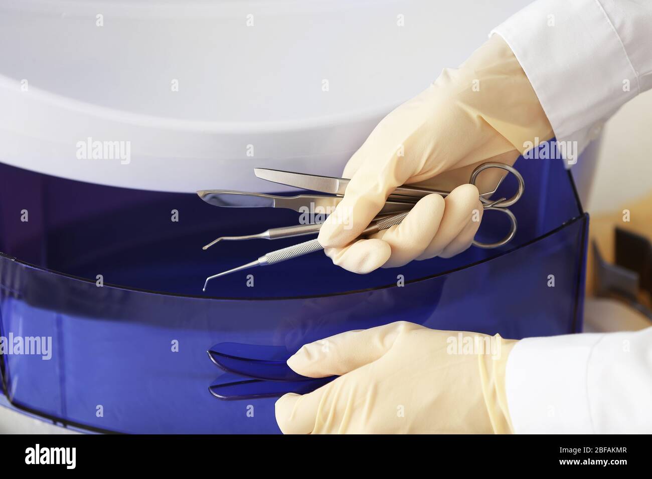 Doctor putting medical instruments into ultraviolet sterilizer in