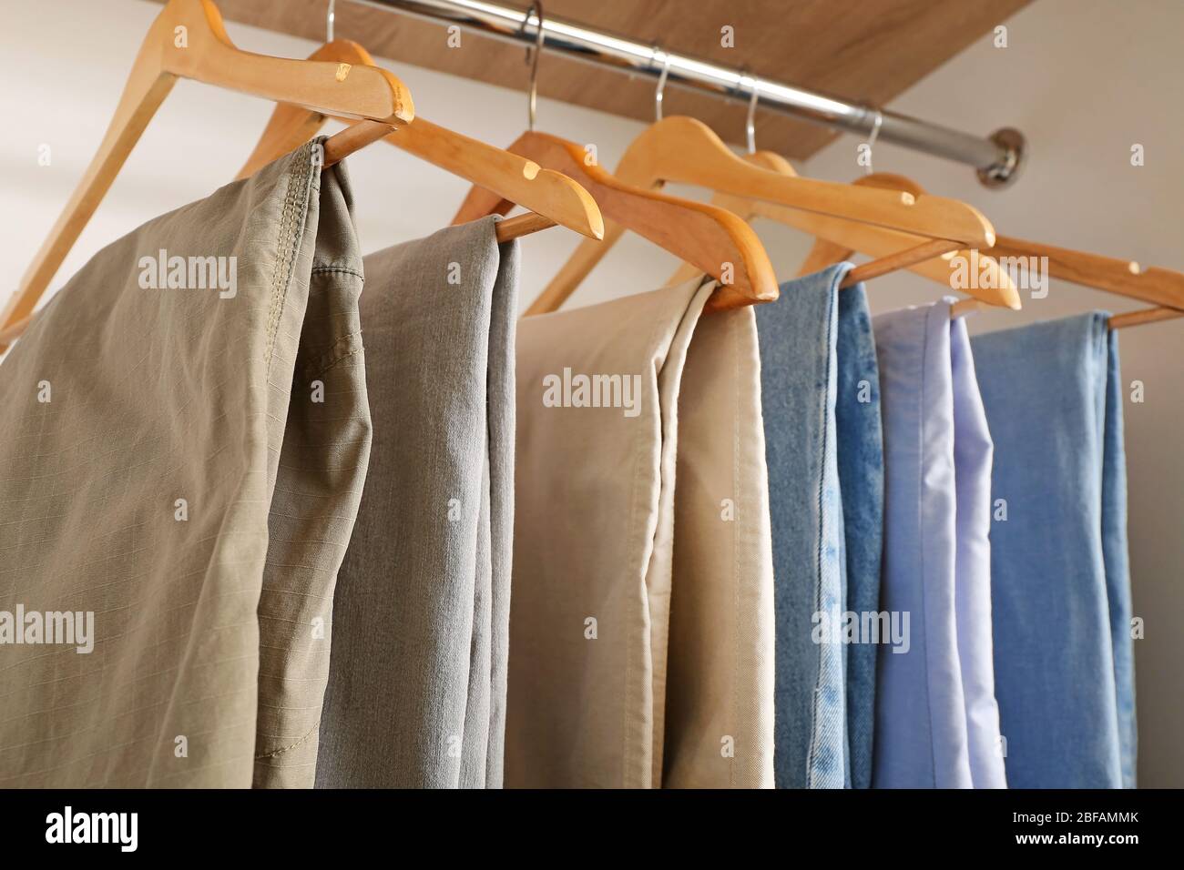 Stylish male clothes on hanger in wardrobe Stock Photo Alamy
