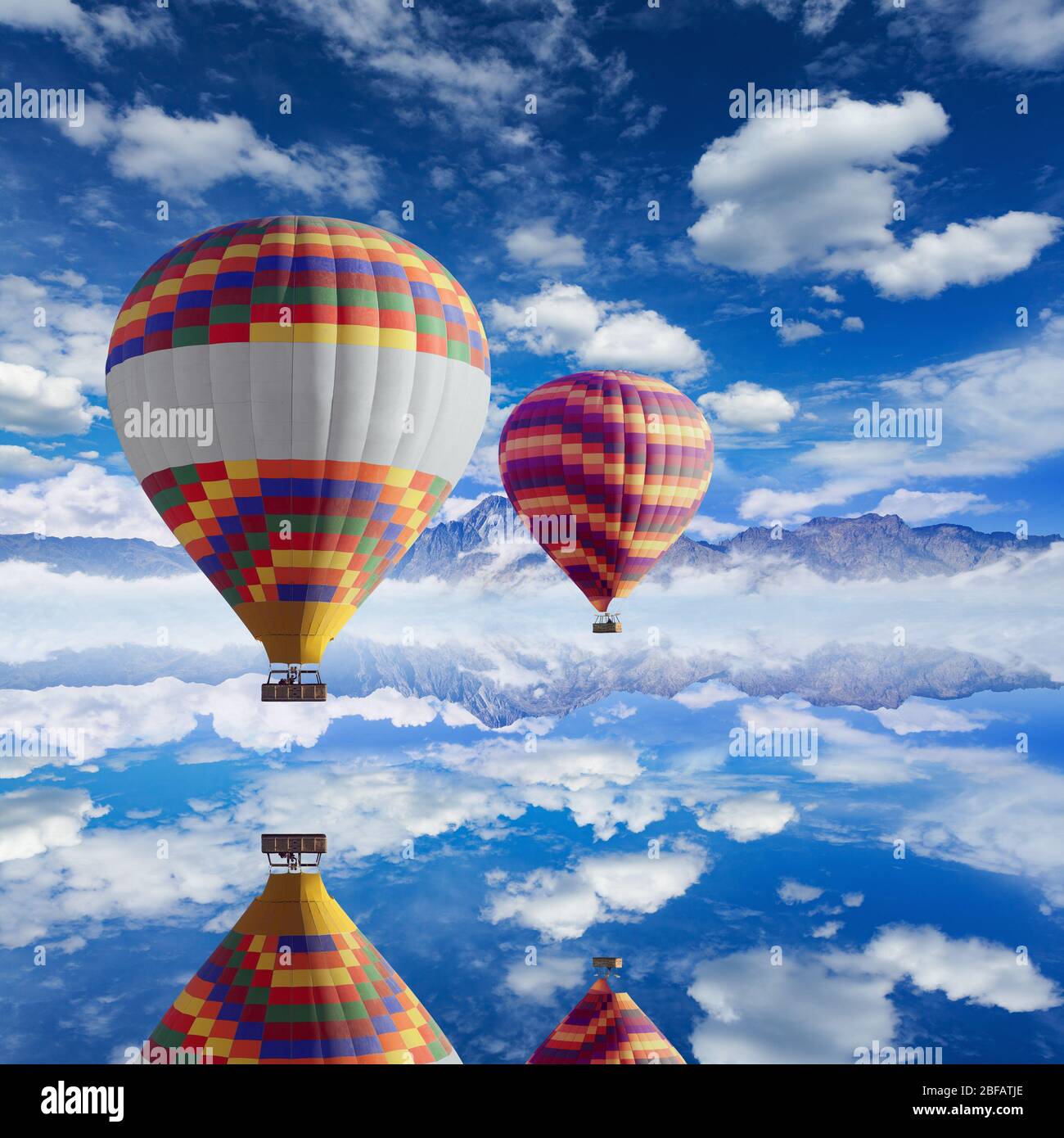 Colorful hot air balloons flies above calm lake, white clouds in blue sky,  high mountains on horizon Stock Photo - Alamy