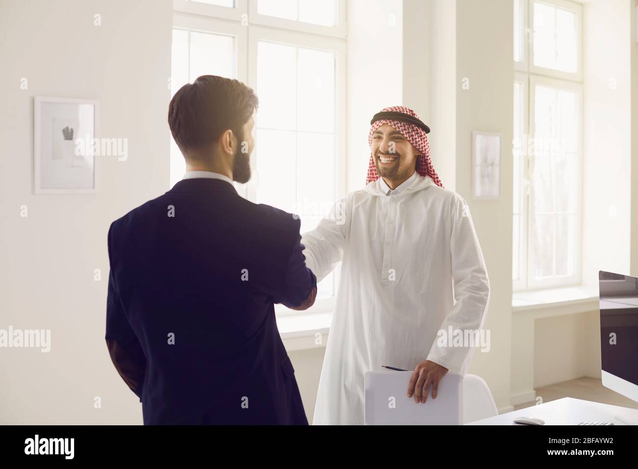 Handshake of arabic and european businesspeople in office. Stock Photo