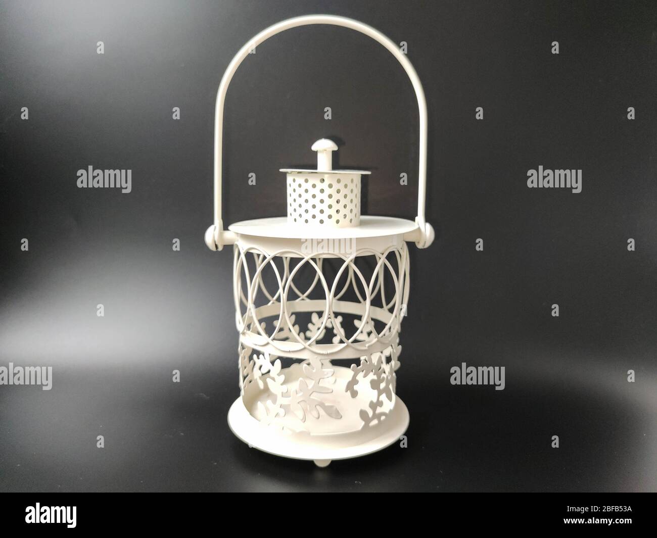 White vintage lantern with an orange candle on black. Concept - Ramadan kareem holiday celebration. Royalty Free Stock image Stock Photo