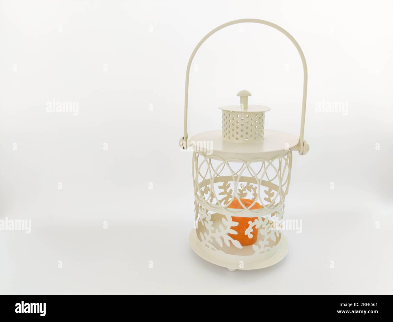 Vintage lantern with an orange candle on the white backdrop. Concept - Ramadan kareem holiday celebration. Royalty Free Stock photo Stock Photo