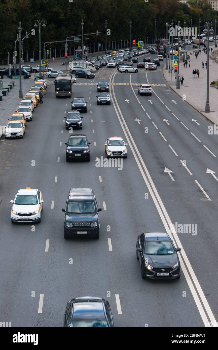 Moscow, Russia - August 2019. Traffic In the photo, a lot of cars - mainly passenger passenger taxis - rush along the three-lane road to the viewer, a Stock Photo